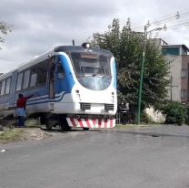 Emocionada, una salteña acerca unas empanaditas a los maquinistas del tren de pasajeros
