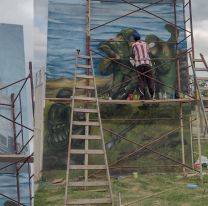 Jóvenes pintan un enorme mural en homenaje a la historia y a la unión nacional